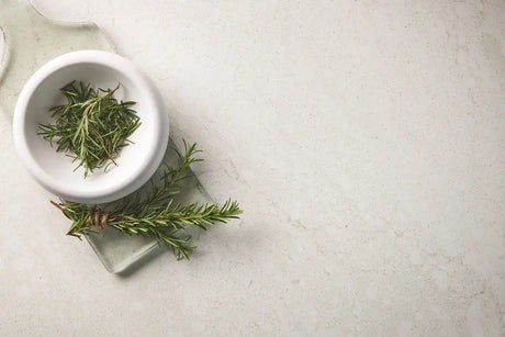 White bowl with green herbs on a light gray surface
